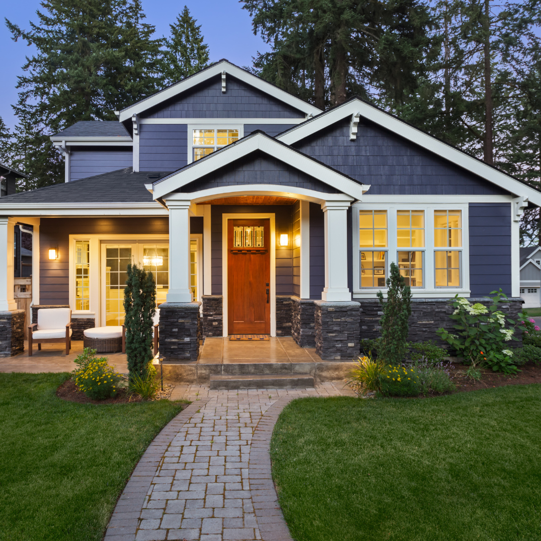 A blue and white house with a brick walkway leading to it