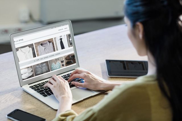Person using a laptop to browse an online shopping site at a desk