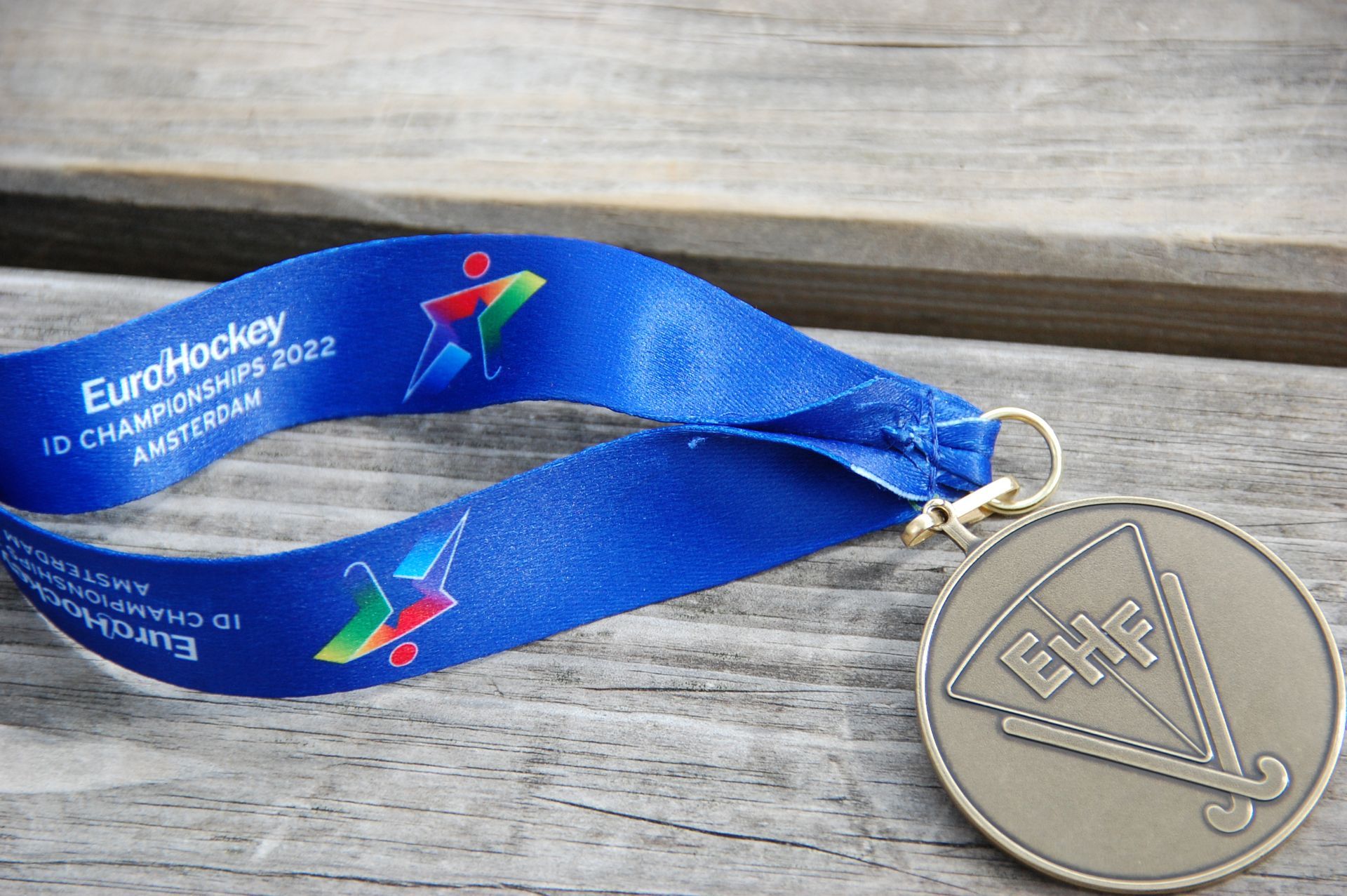 Medaille met blauw lint. Tekst 