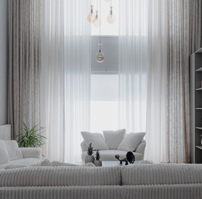 Witte inbetween gordijnen in een lichte woonkamer