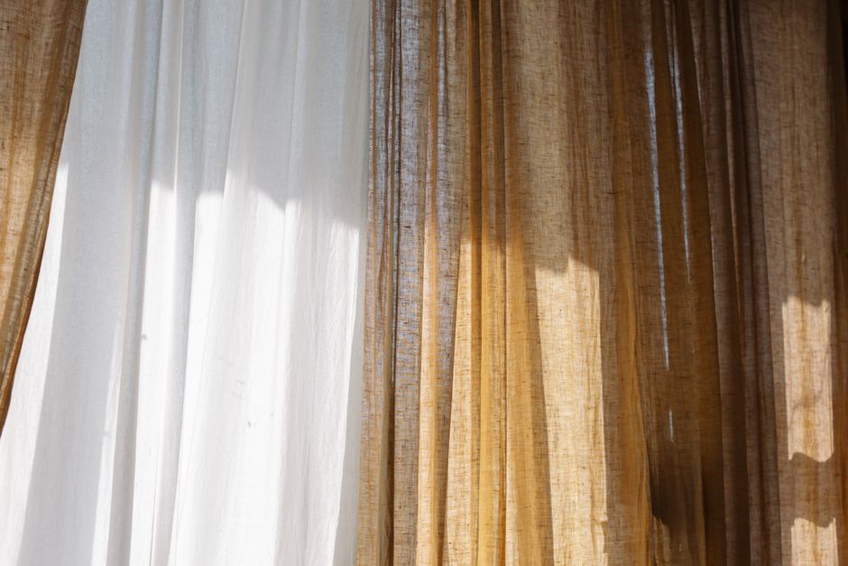 Lichte linnen gordijnen voor een raam in een woonkamer