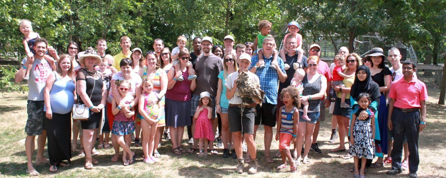 a large group of people are posing for a picture in a park during an educational zoo tours niagara