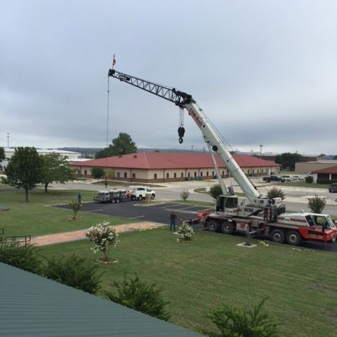 A large crane is sitting on top of a truck in a grassy field from AFA Service HVAC