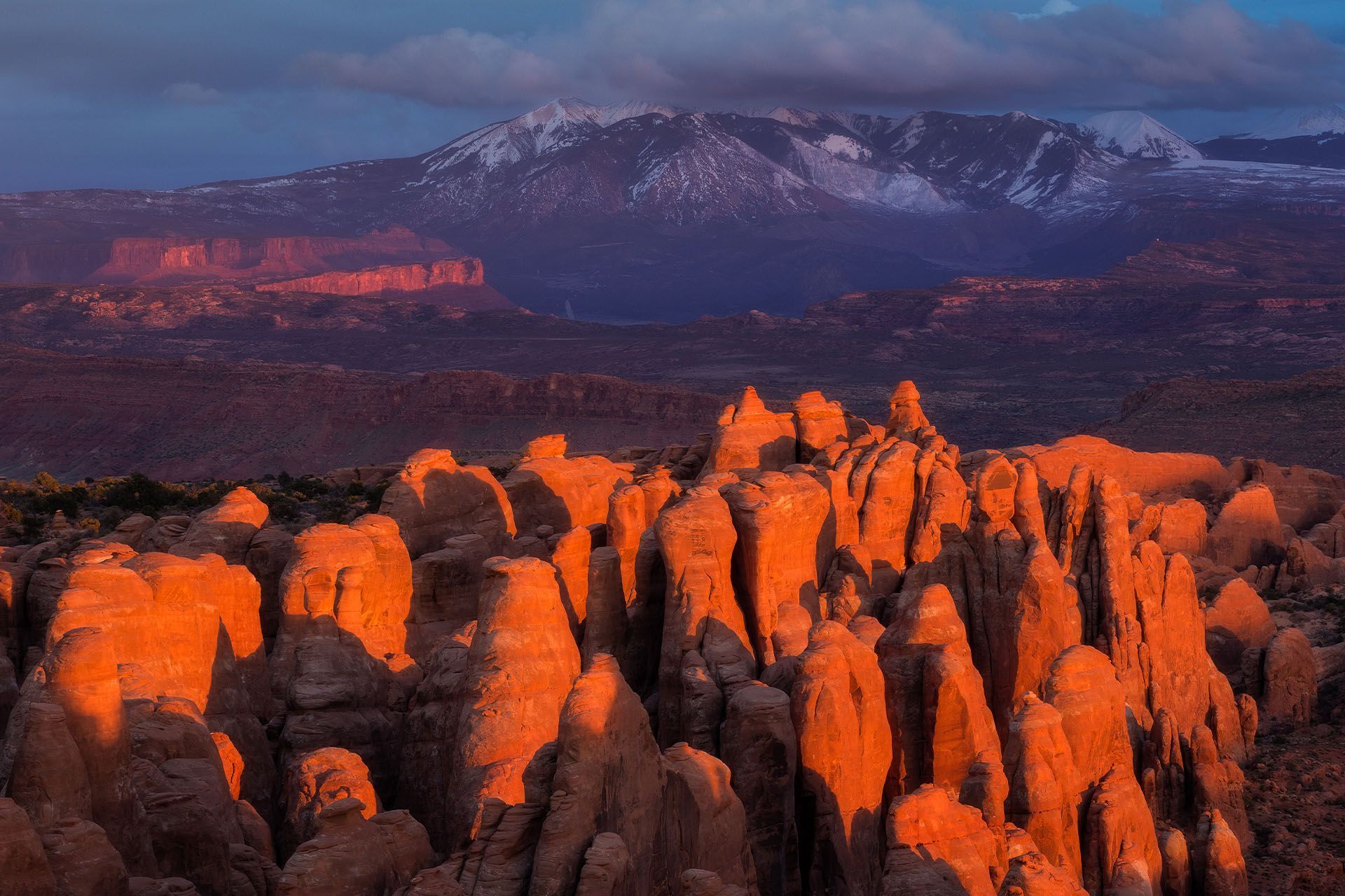 A large rock formation in the middle of a canyon with a cloudy sky in the background.