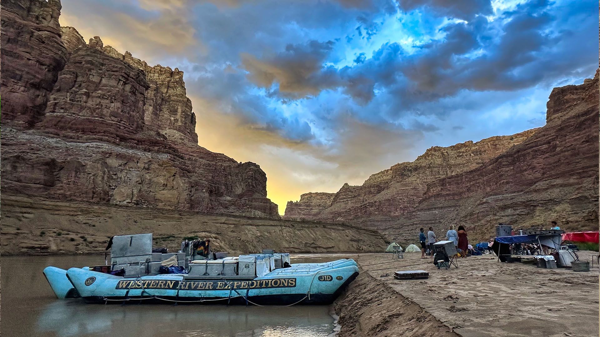 Canyon cliffs glowing at sunset reflected in a calm river pool under a blue sky