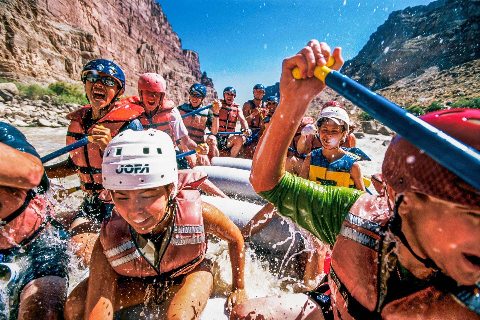 A group paddling a raft down Cataract Canyon