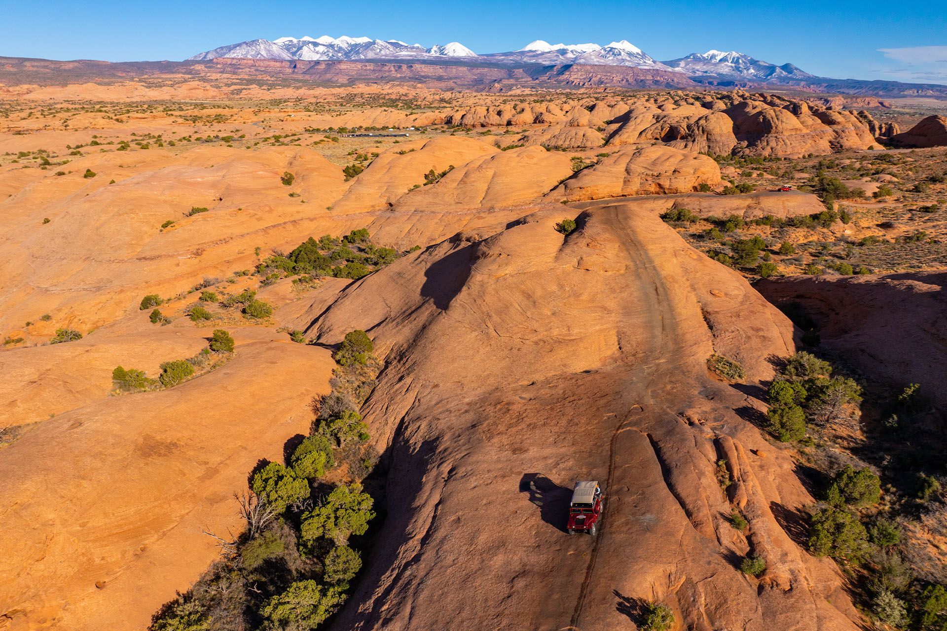 A Hummer Tour driving up a slickrock fin on Hells Revenge trail in Moab.