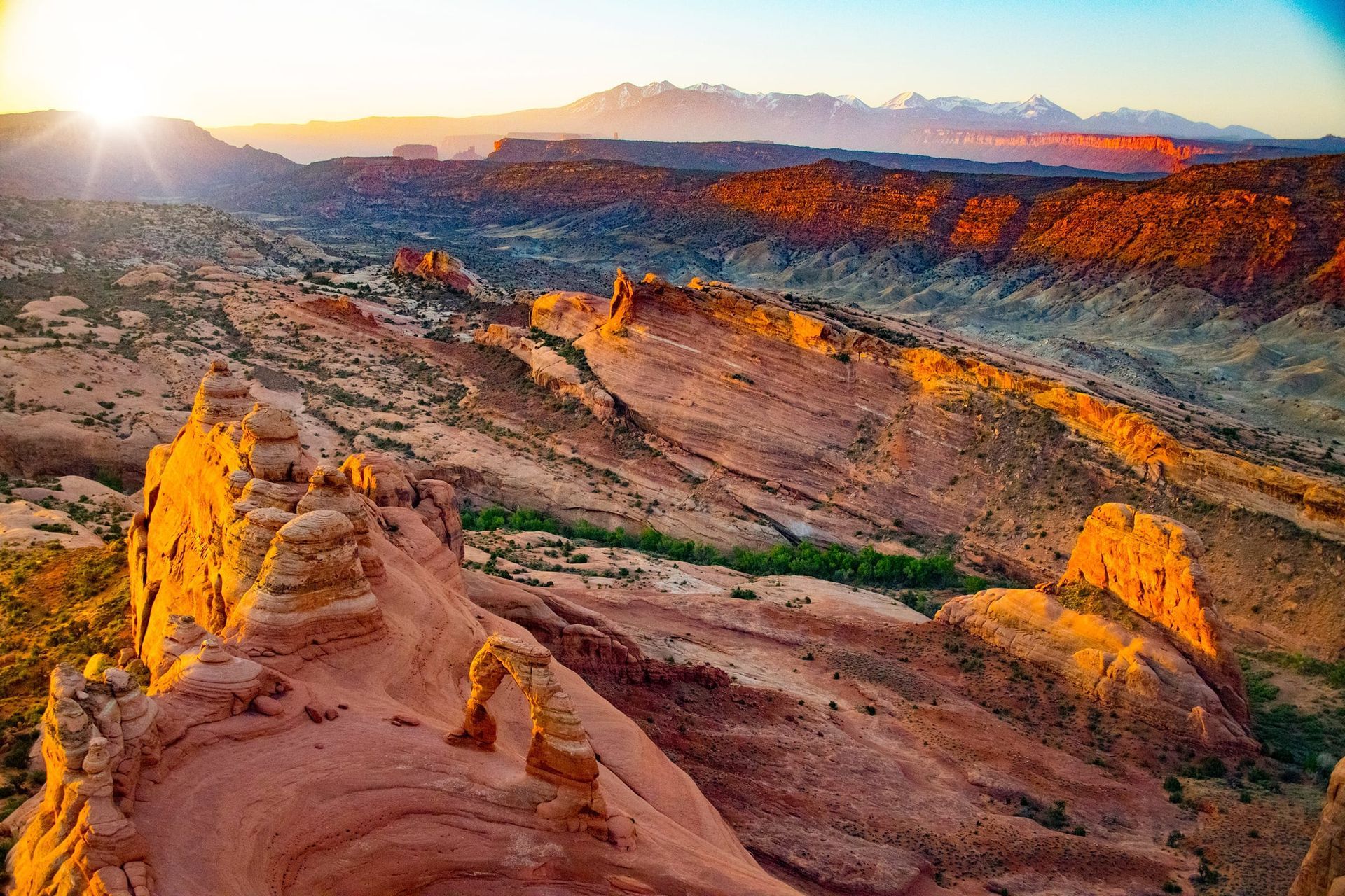 Sunrise over Arches National Park with Delicate Arch in the foreground as seen from the air.