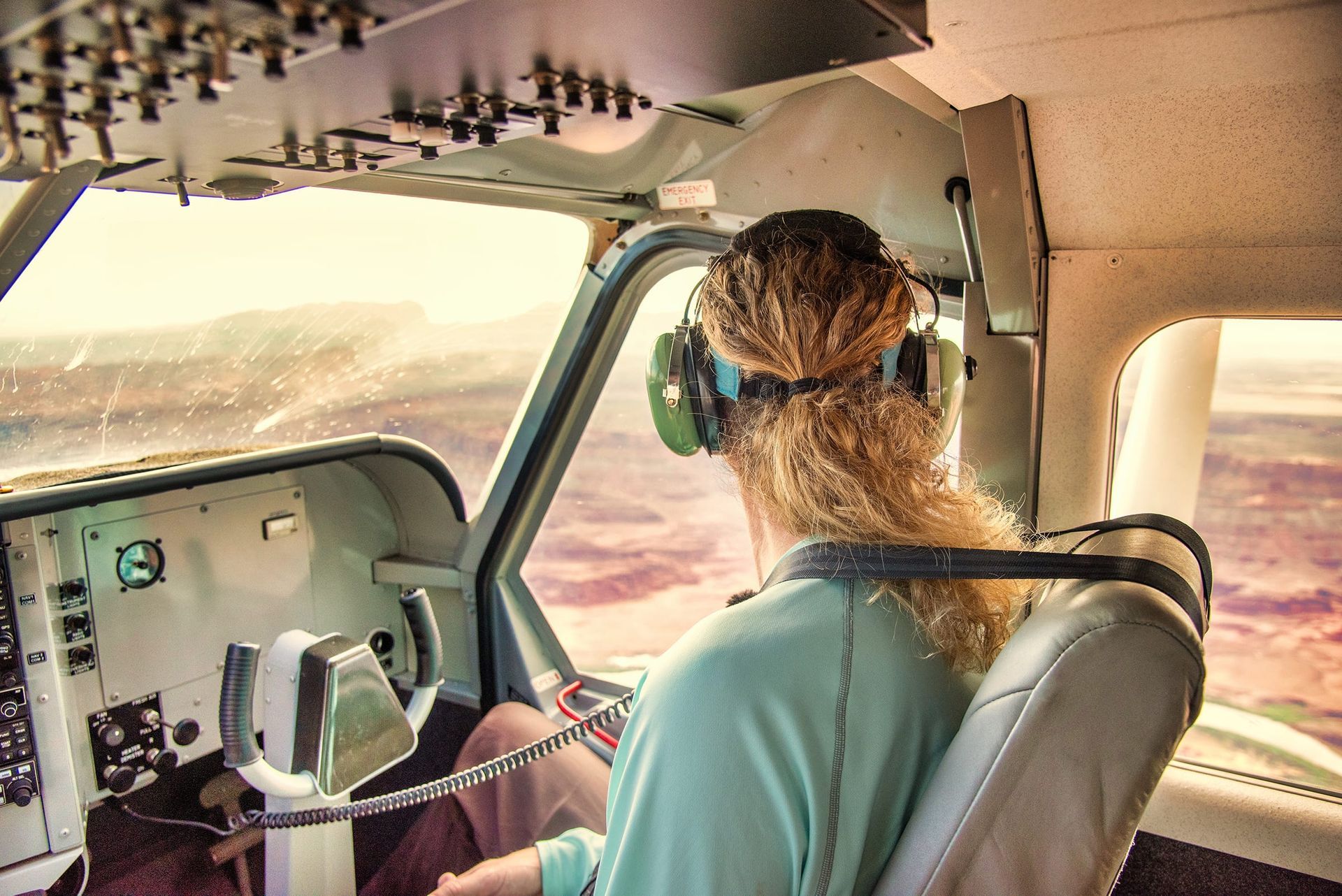 Man seated in the front of an airplane looking out the window
