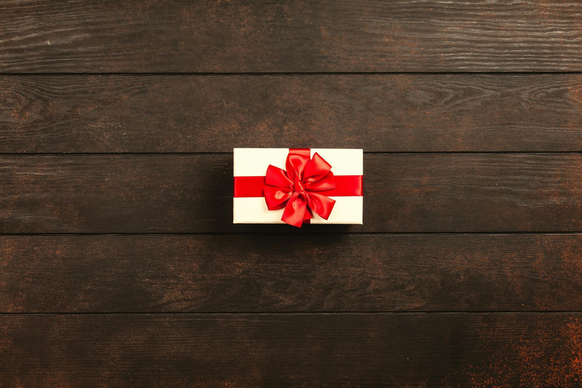 A gift of Moab Adventure Center Gift cards in a small box on a dark wood background