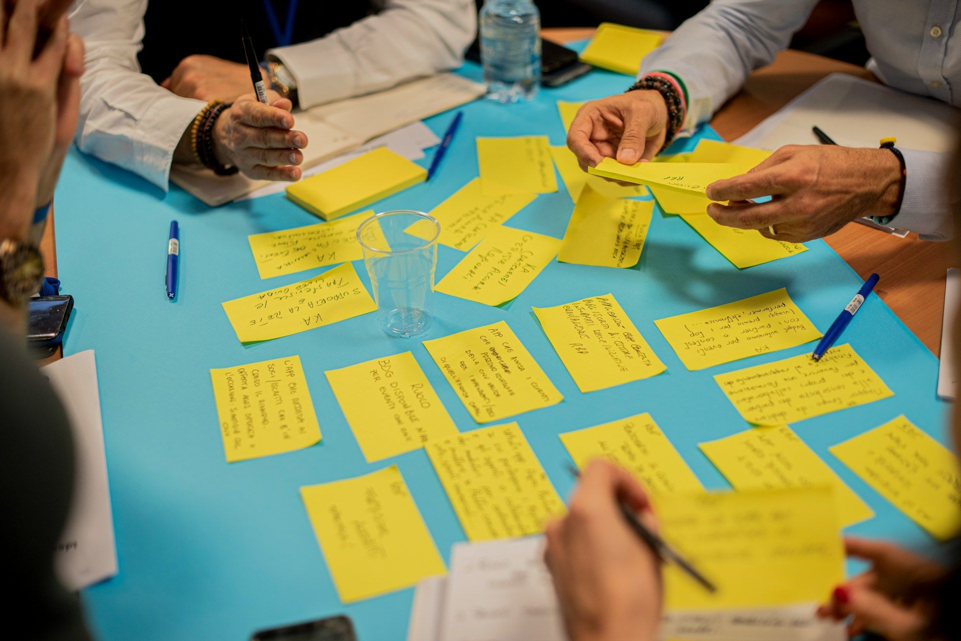 Group sitting at table with poster full of post its doing training and workshop