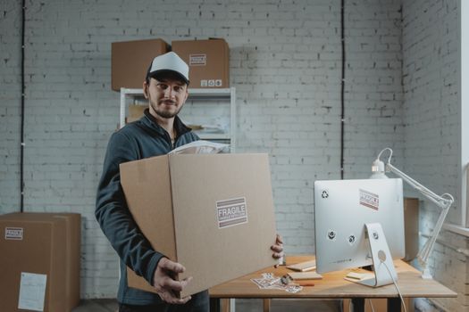 Operarios trasladan escritorios y cajas con equipos de cómputo fuera de una oficina moderna.
