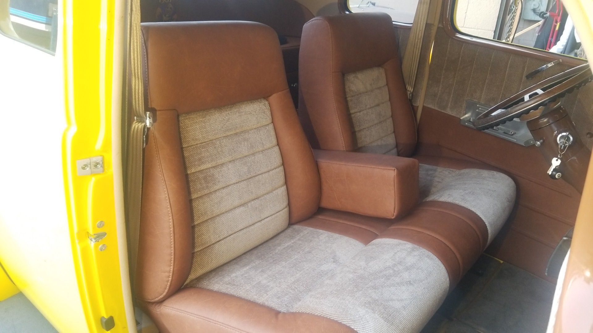 Brown and gray upholstered car seats inside a yellow vehicle interior