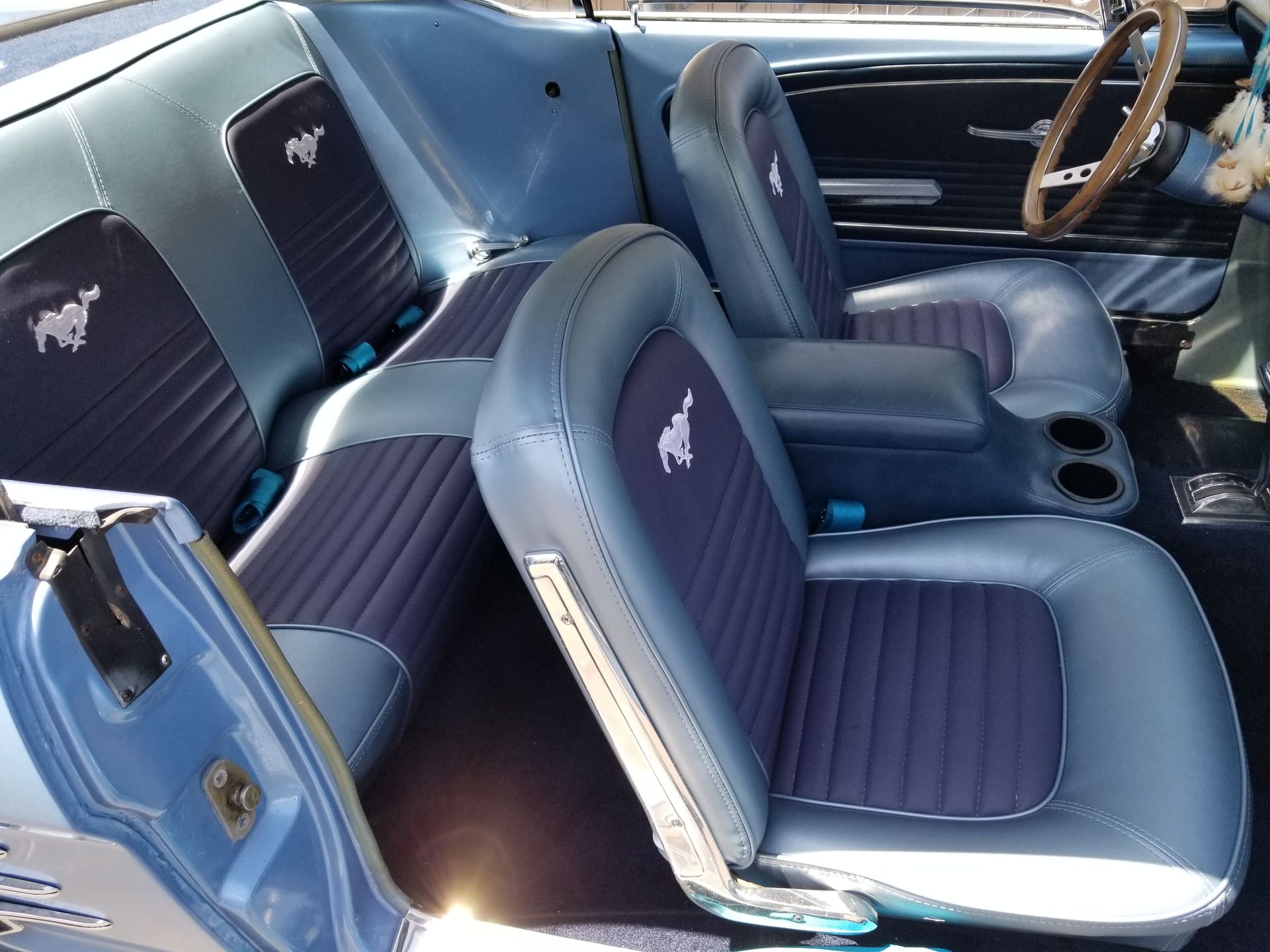 Blue vintage car interior with Mustang-logo bucket seats and black dashboard