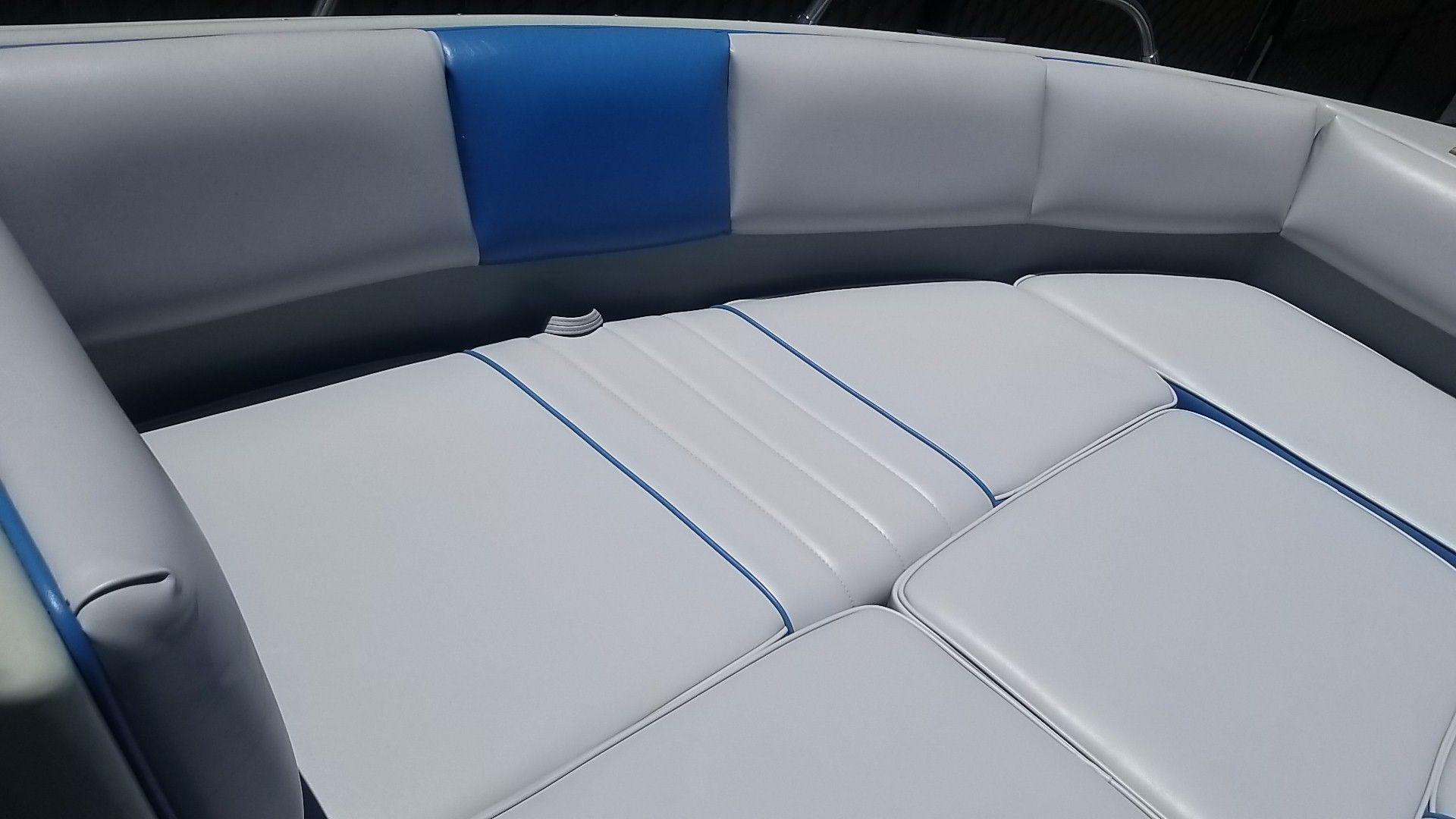 Gray and blue upholstered boat seating with curved backrest