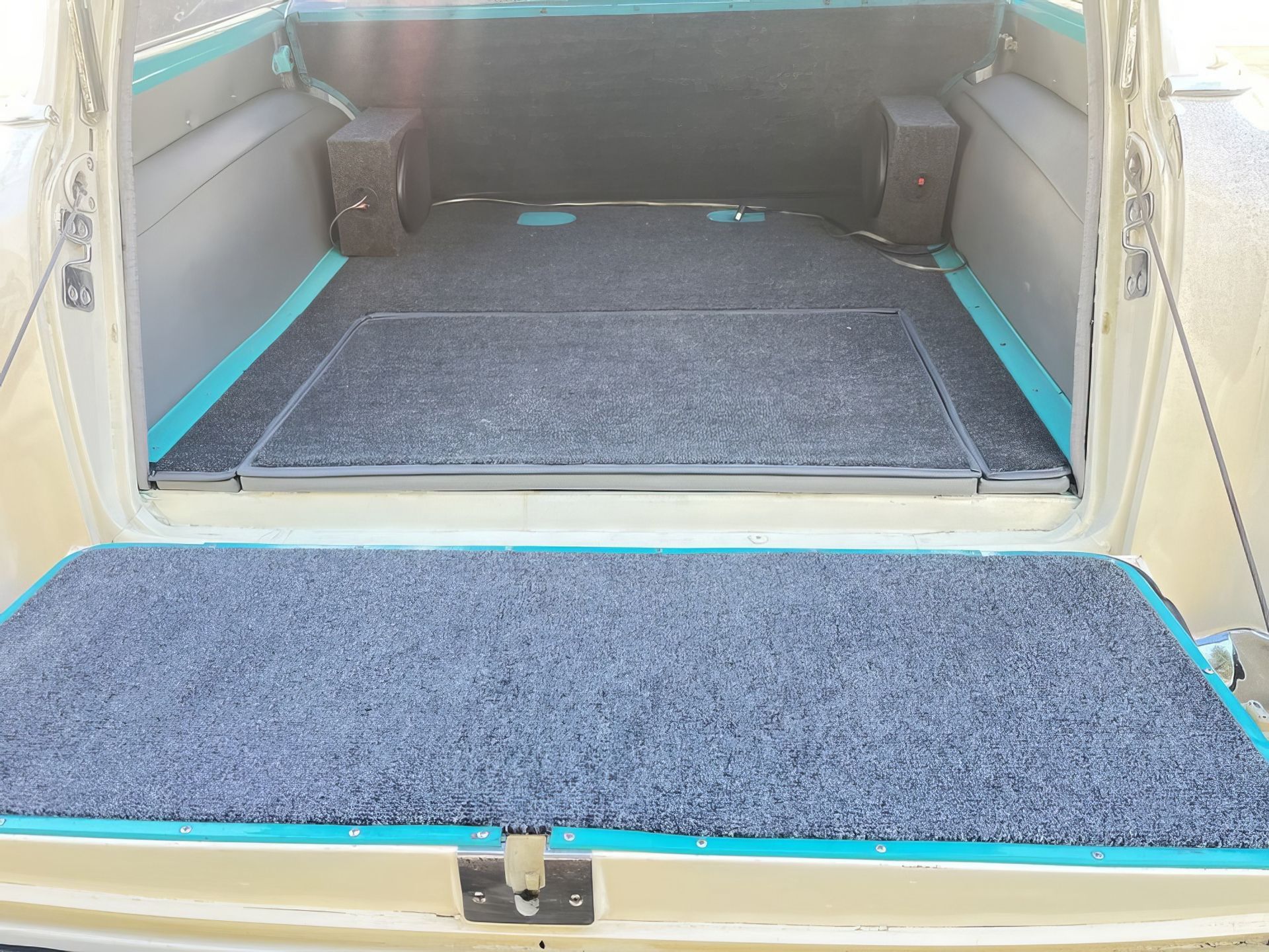 Cargo van interior with folded ramp and blue-edged carpeted floor