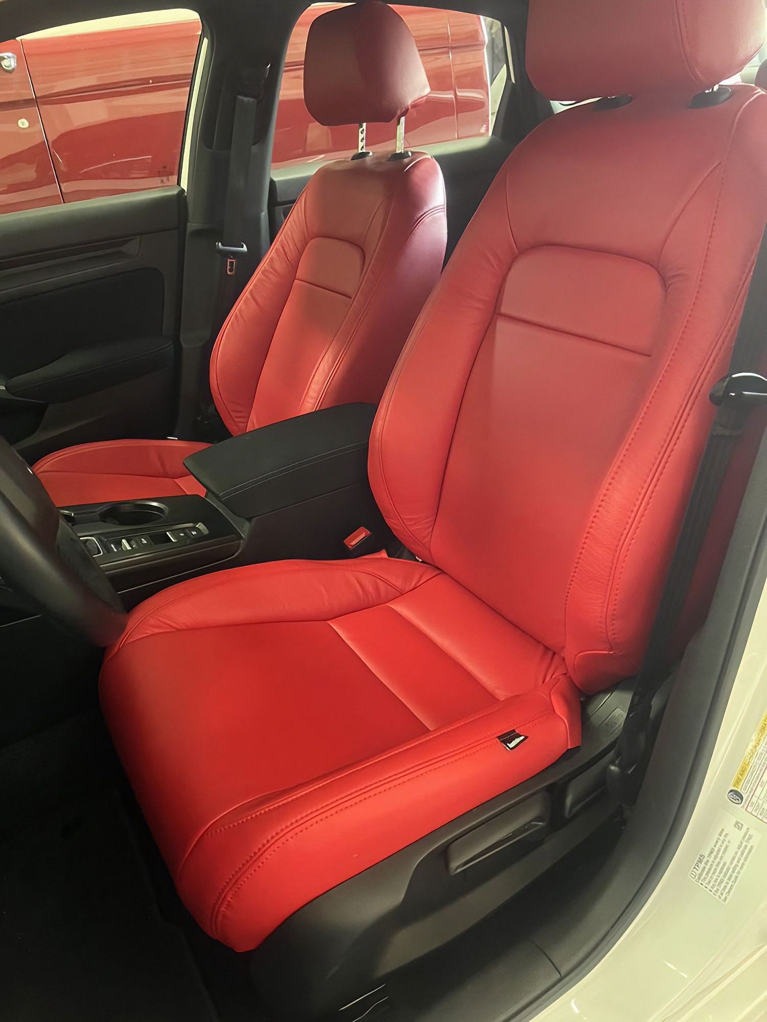 Red leather car seats and interior viewed from the open passenger door