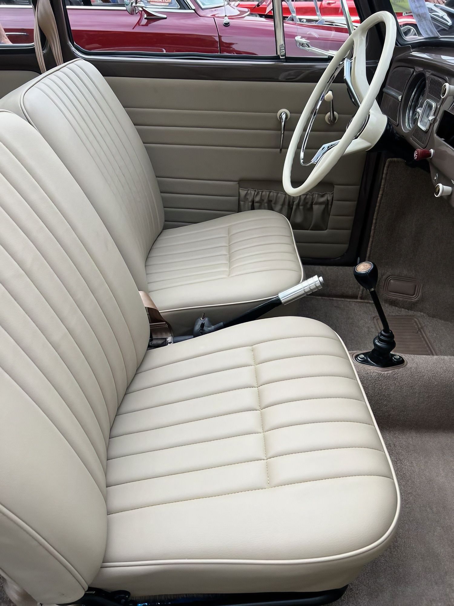 Cream-colored car front seats and steering wheel in a vintage interior
