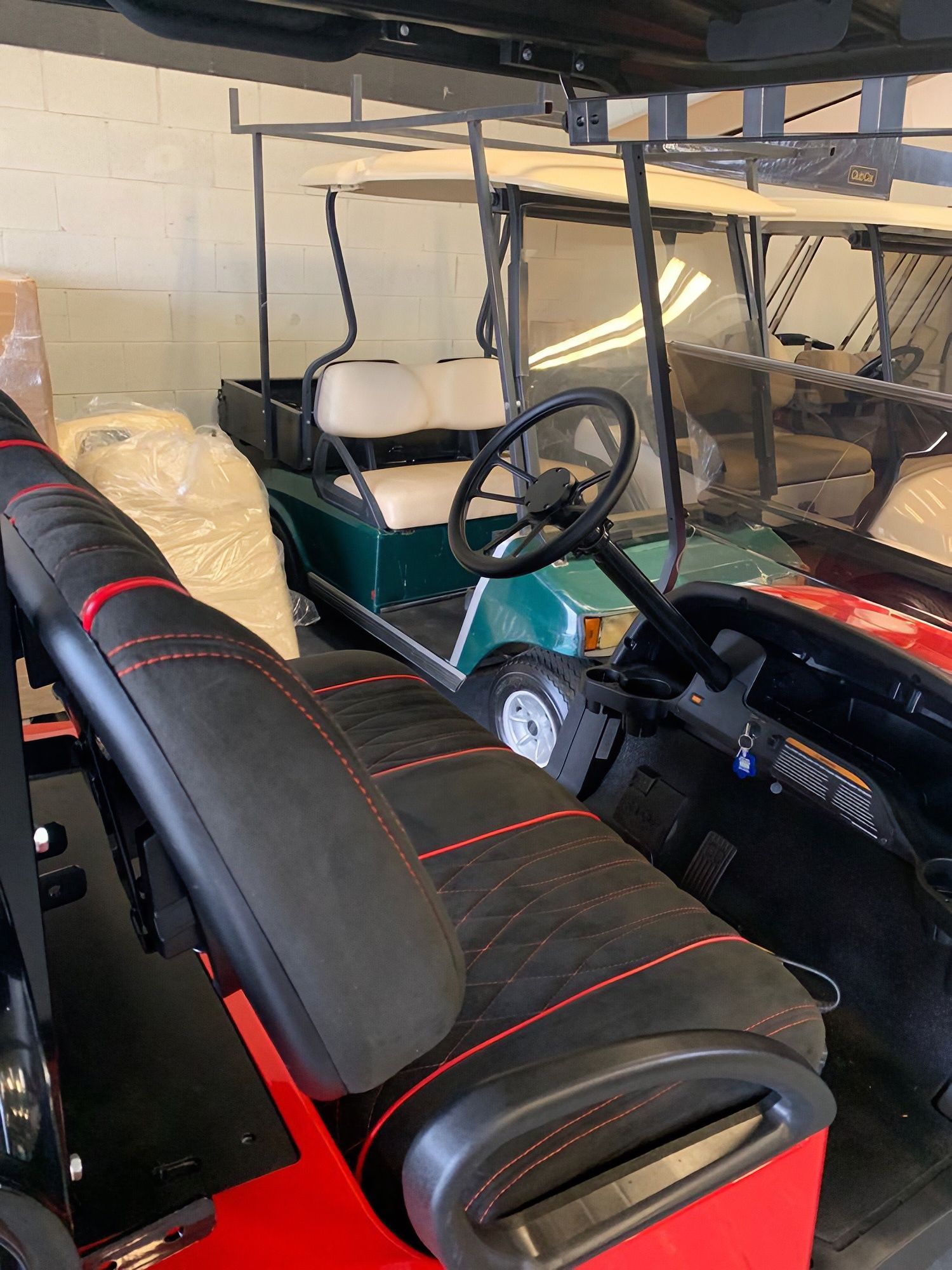Black golf cart with red-trim seats parked in a garage