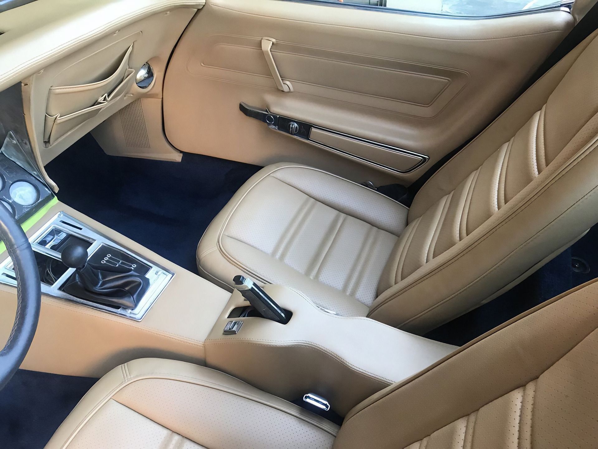 Beige leather car interior with front seats, center console, and manual gear shifter