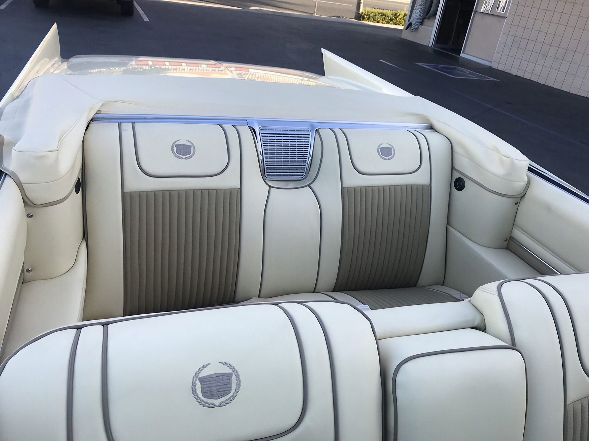 White leather boat seating with gray accents and a centered blue-striped vent panel