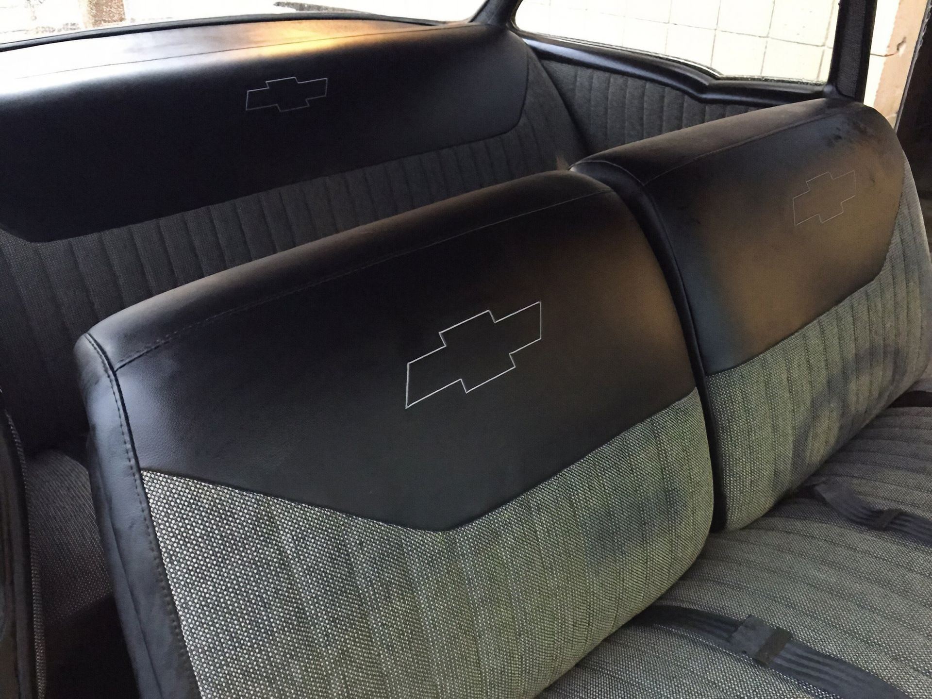 Chevrolet truck rear bench seat with black and gray upholstery and embroidered logos
