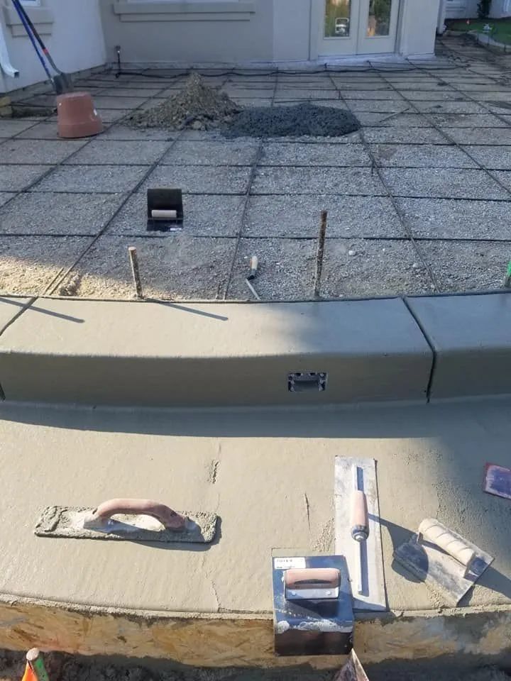 Rooftop with gravel and concrete sections, small vents, and two cushioned chairs near the edge.