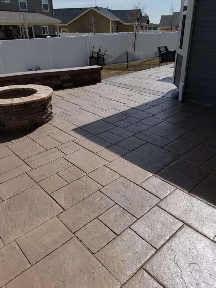 Stamped concrete patio with fire pit and retaining wall; tan and gray colors.