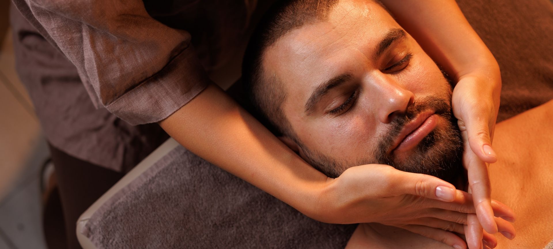 Un homme barbu se faisant faire un massage relaxant.