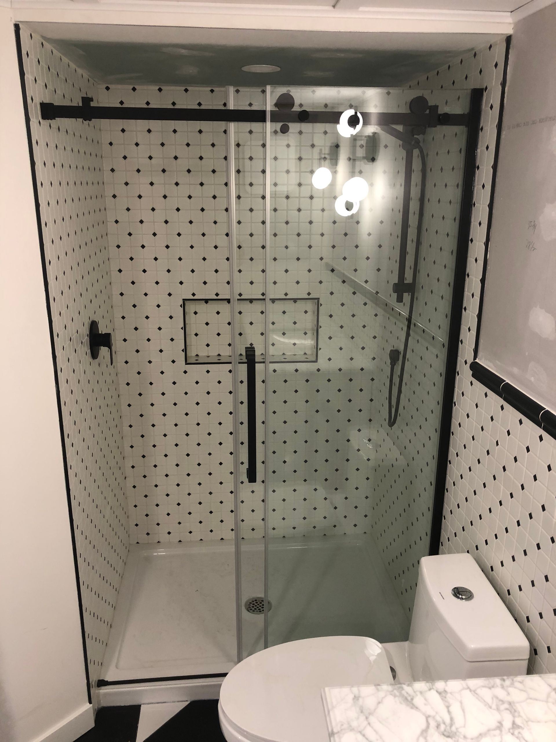 Une salle de bain avec WC et douche avec porte coulissante vitrée