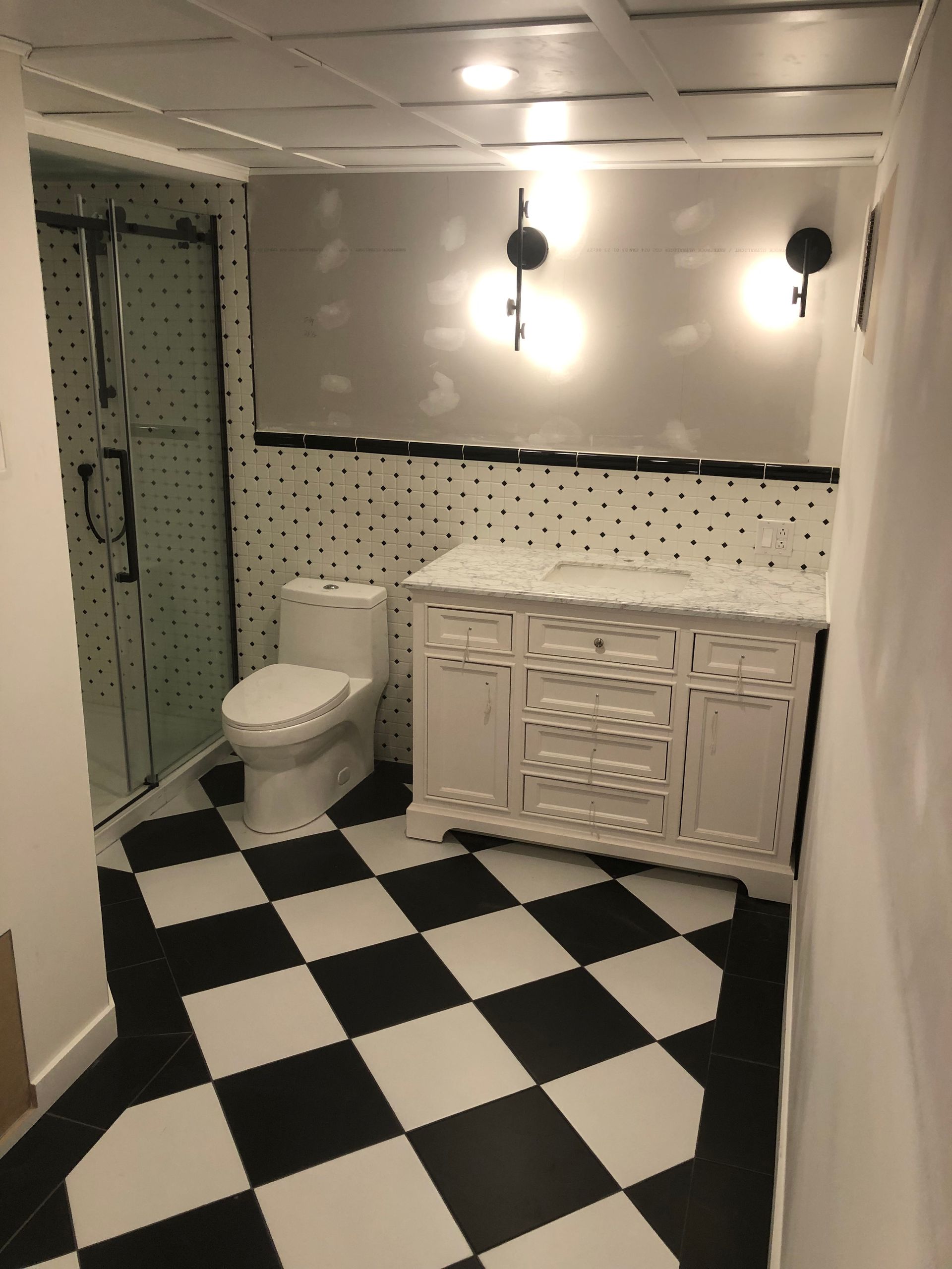 Une salle de bain avec un sol en damier noir et blanc