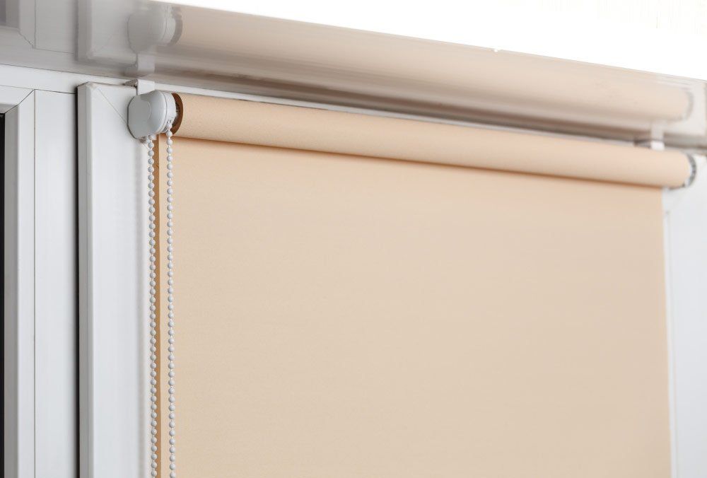 Beige Blockout Roller Blinds On White Window — Studio Curtains & Blinds in Mount Gravatt, QLD