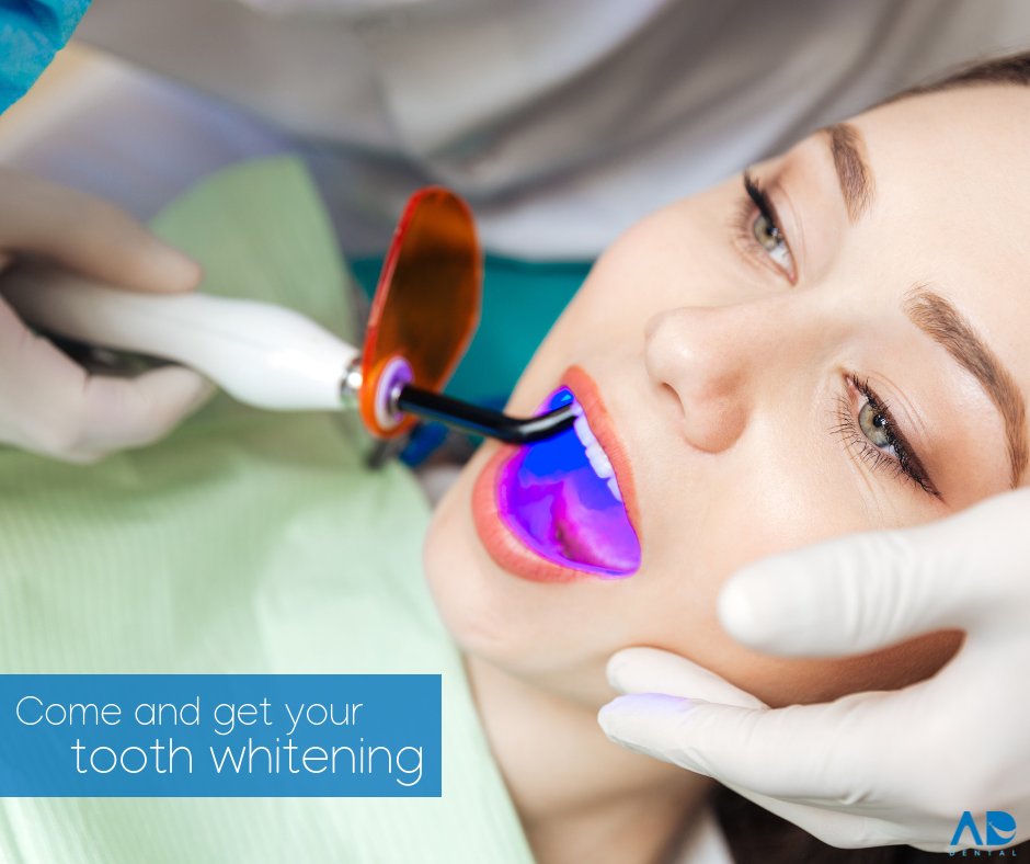 Woman undergoing teeth whitening treatment with dental equipment.