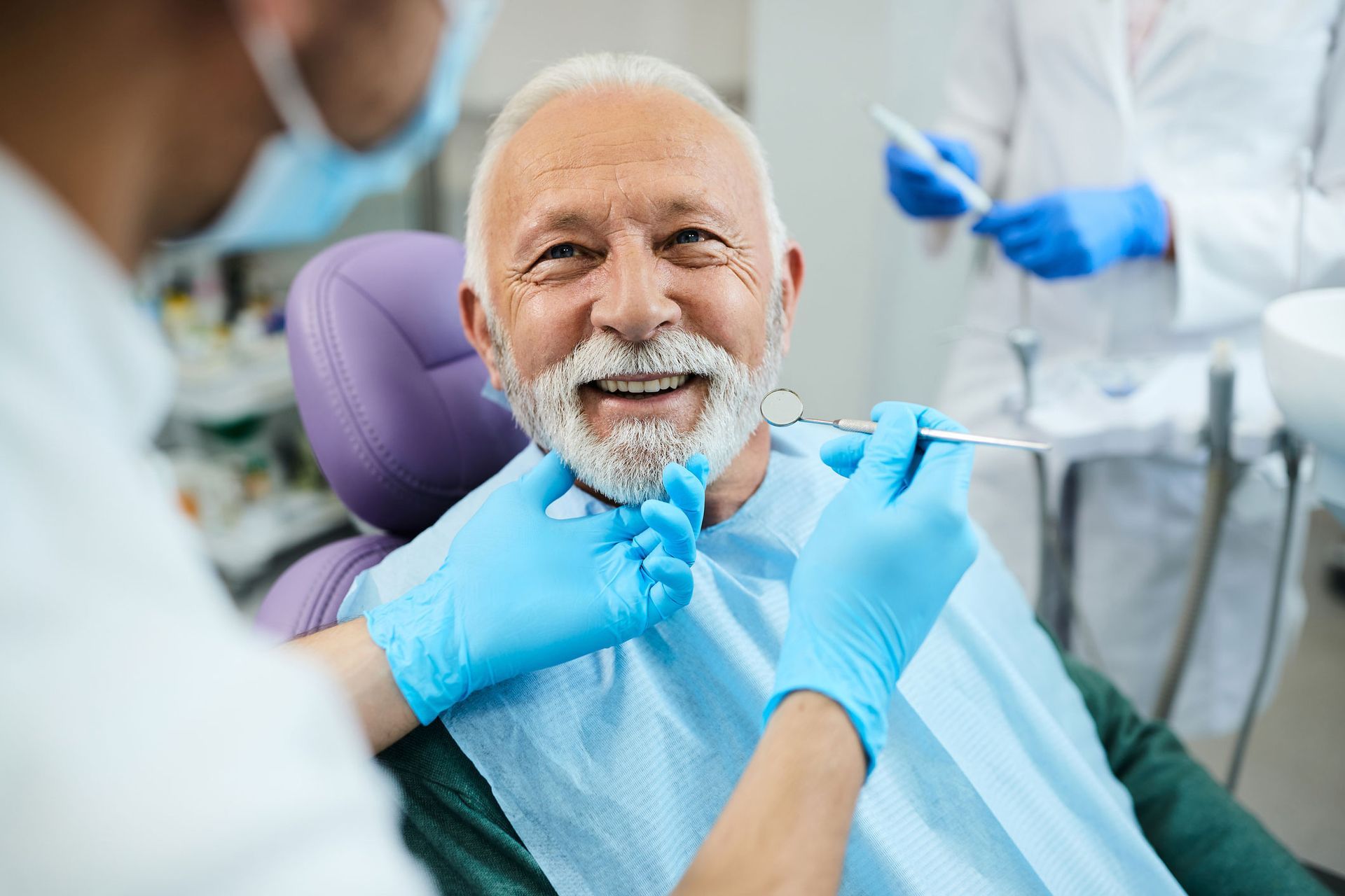 Dentist examining a patient's teeth in a dental chair. 