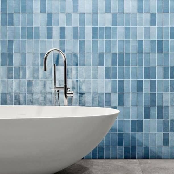 Modern white bathtub with chrome faucet against blue tiled bathroom wall — Unique Floors In New Town, TAS