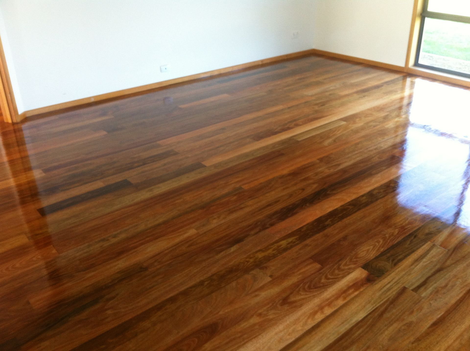 Empty room with glossy wooden floor and white walls, sunlight coming through a window — Unique Floors In New Town, TAS