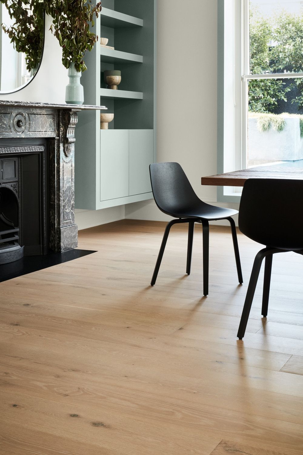 Bright dining room with wood floors, black chairs, and built-in shelves beside a fireplace. — Unique Floors In New Town, TAS