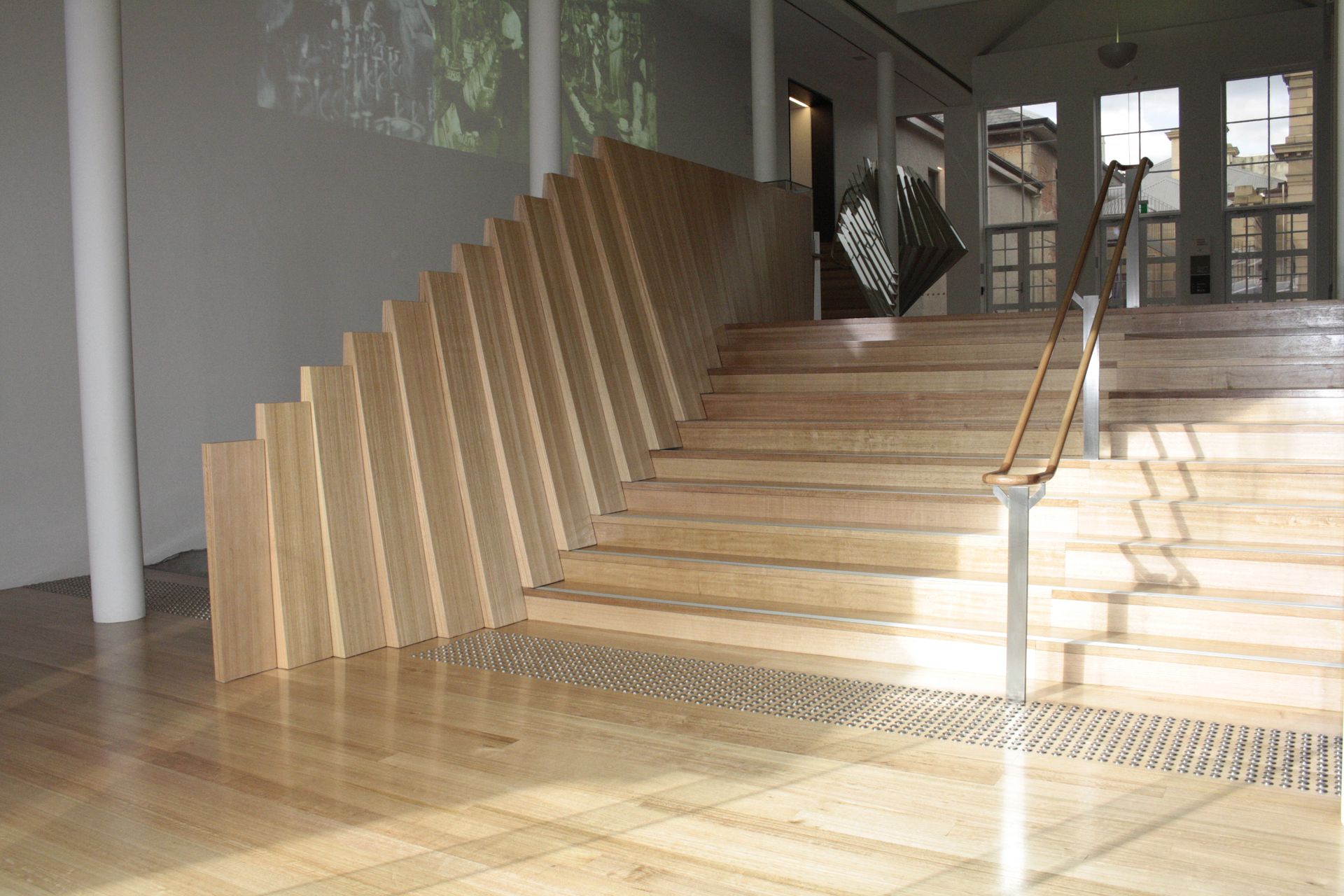 Modern wooden staircase with striped steps and a handrail in a bright interior hallway — Unique Floors In New Town, TAS