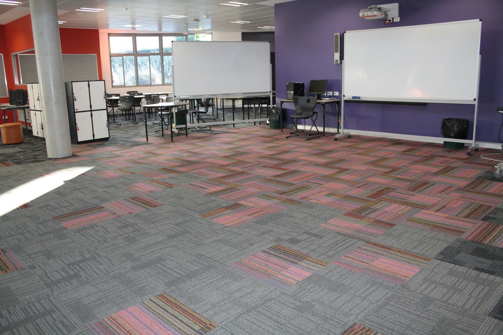 Empty classroom with whiteboards, desks, and patterned carpet in a modern office-like space — Unique Floors In New Town, TAS