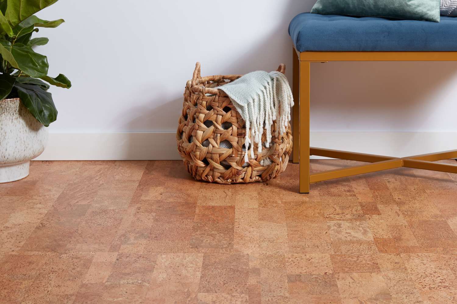 Cozy corner with wood floor, woven basket and throw, potted plant, and blue cushioned chair — Unique Floors In New Town, TAS