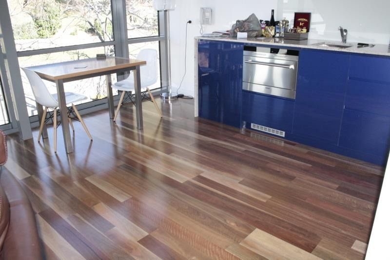 Bright Kitchen With Blue Cabinets, Wood Floor, and a Small Table by the Window — Unique Floors In New Town, TAS