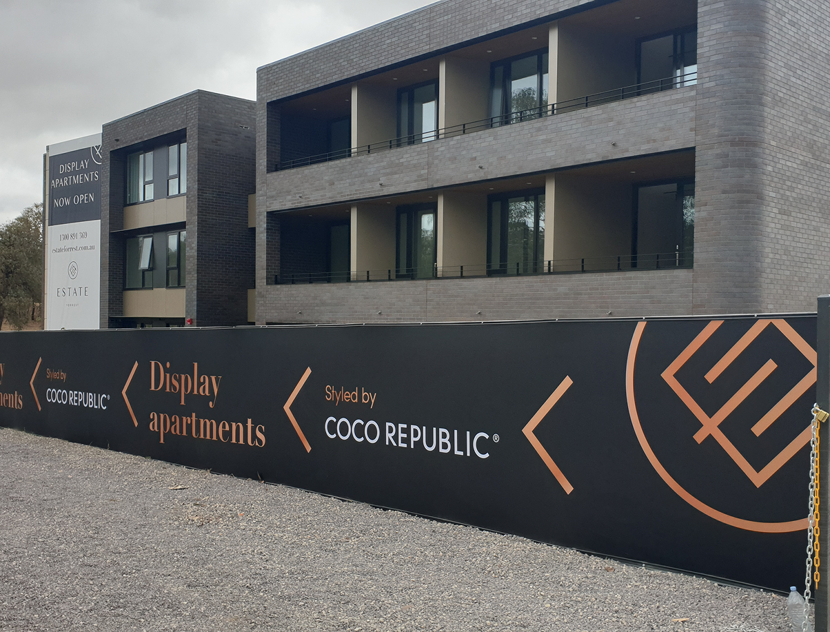 A building with a fence around it that says coco republic