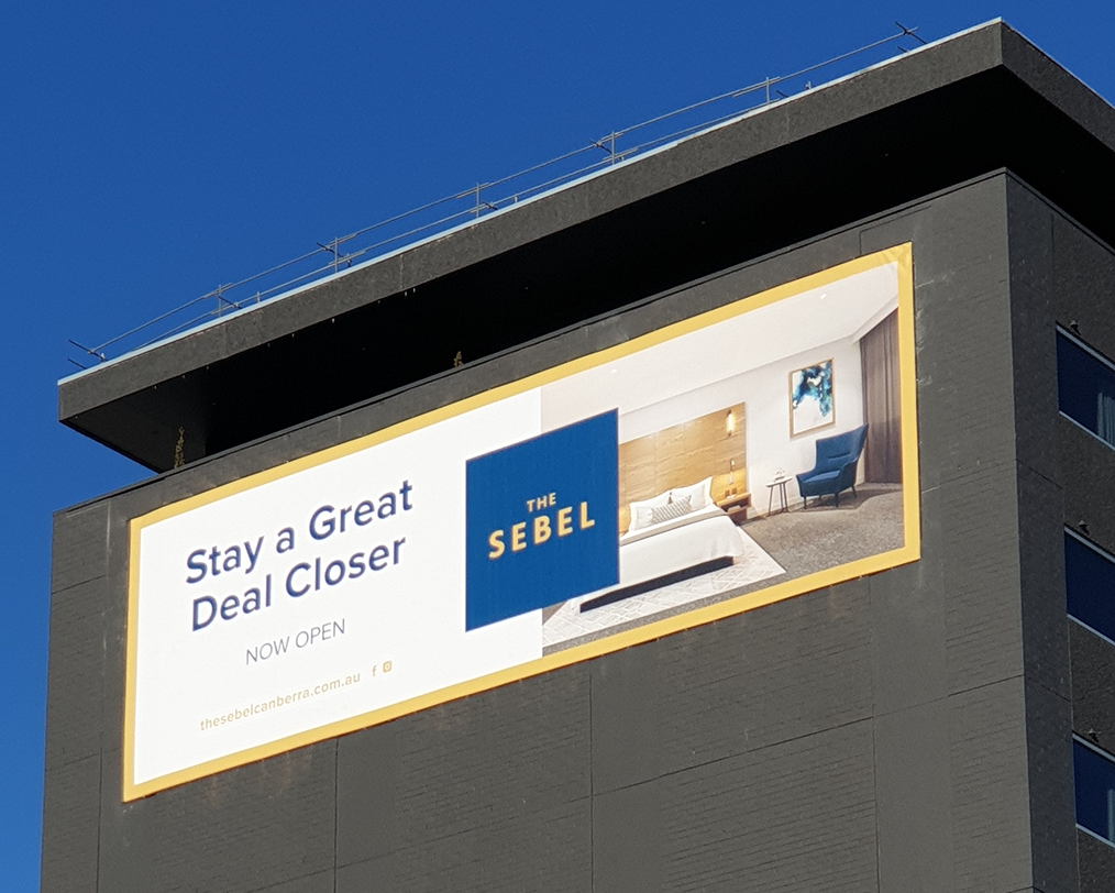A billboard on the side of a building that says stay a great deal closer