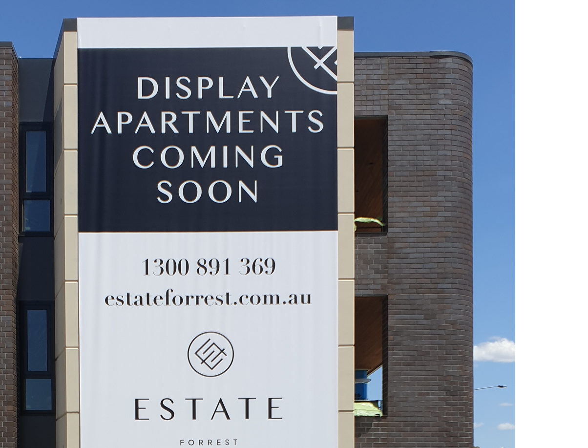 A sign on the side of a building that says display apartments coming soon