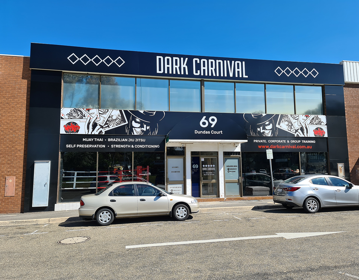 A car is parked in front of a dark carnival store