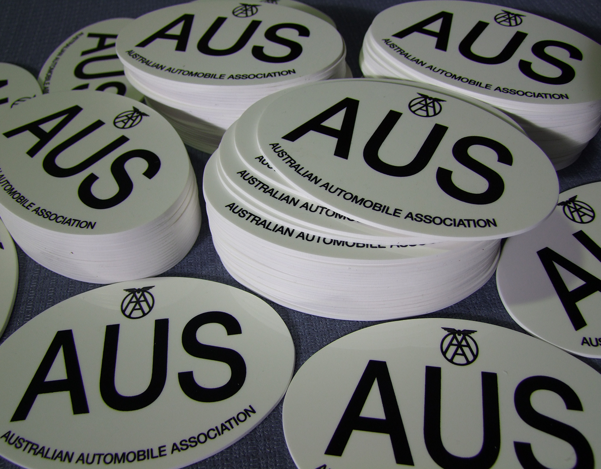 A bunch of aus stickers are stacked on top of each other
