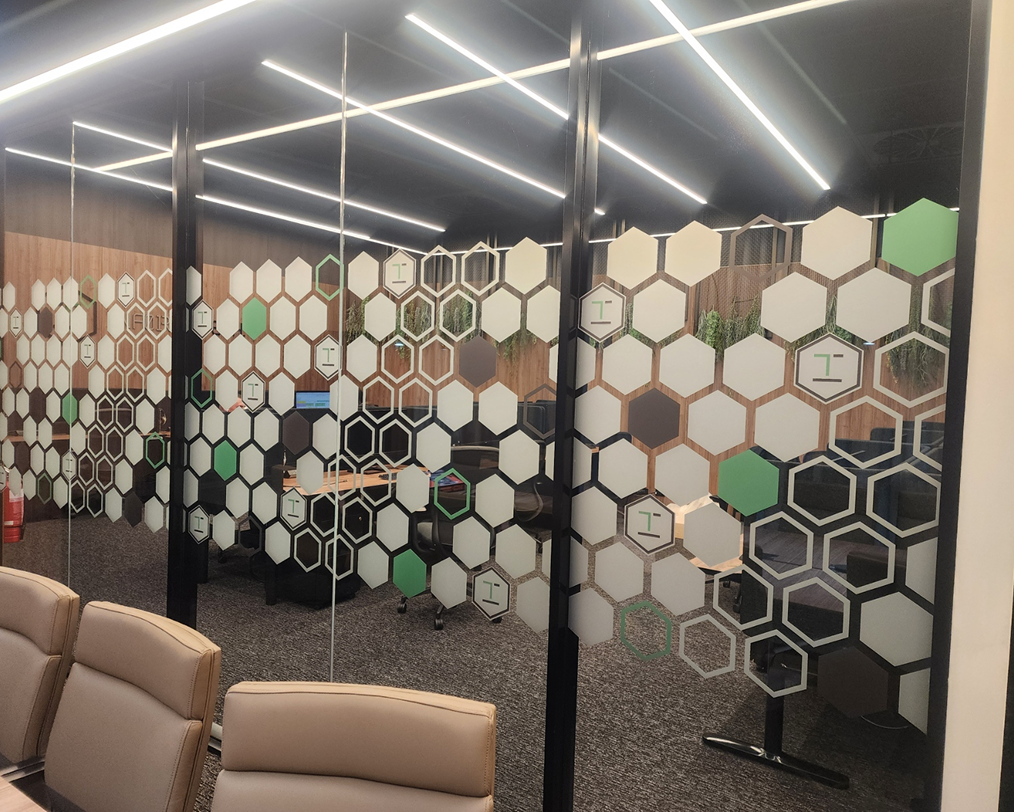 A conference room with a honeycomb design on the glass walls.