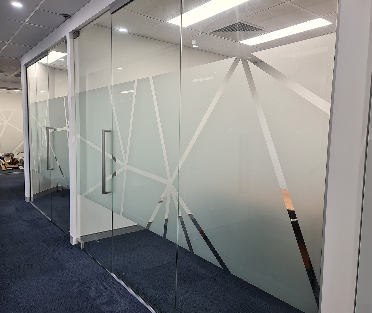 A glass wall with a geometric design on it.