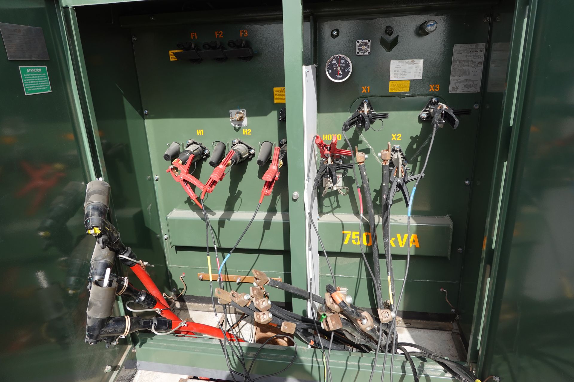 Una caja eléctrica verde con muchos cables saliendo de ella.