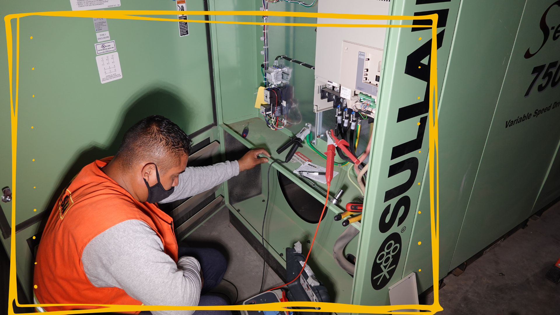 Un hombre que lleva una máscara está trabajando en una caja eléctrica.
